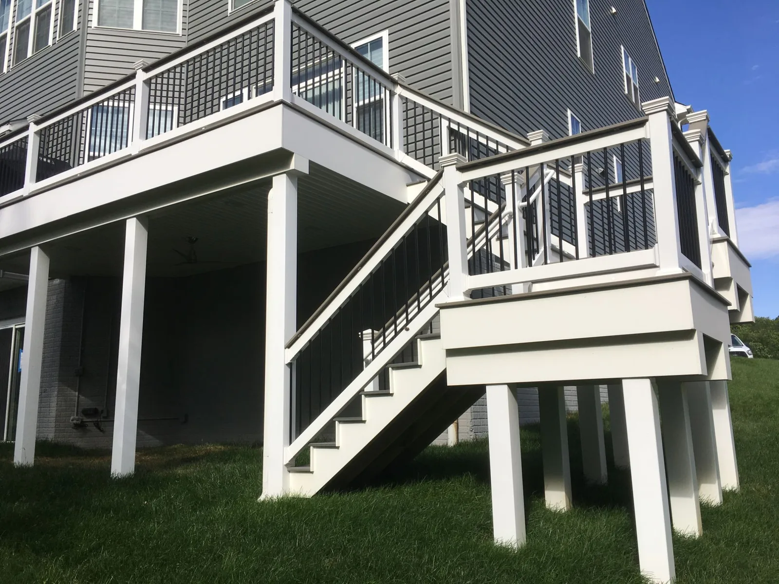 Elevated deck with white columns and black aluminum balusters built by PRG Home Improvement in Maryland