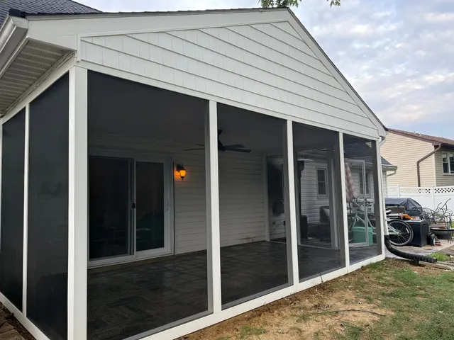 Renovated screened porch with full-height screens, white trim, and shake-style gable after porch remodel in Annapolis MD
