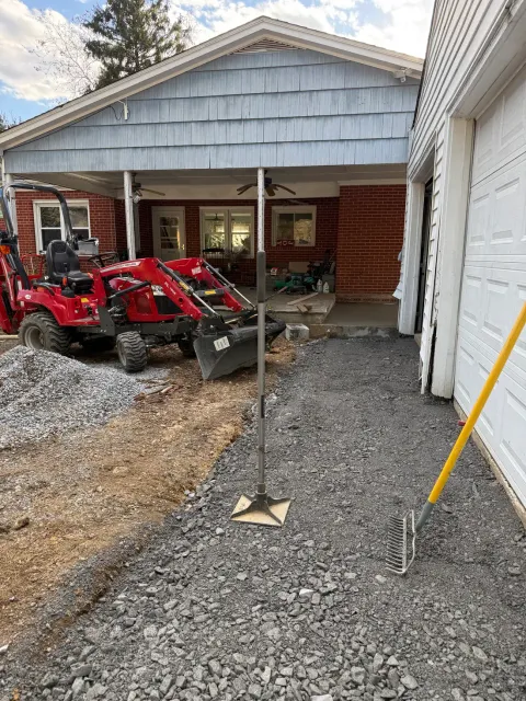 Compact loader spreading gravel base for a Maryland driveway by PRG Home Improvement