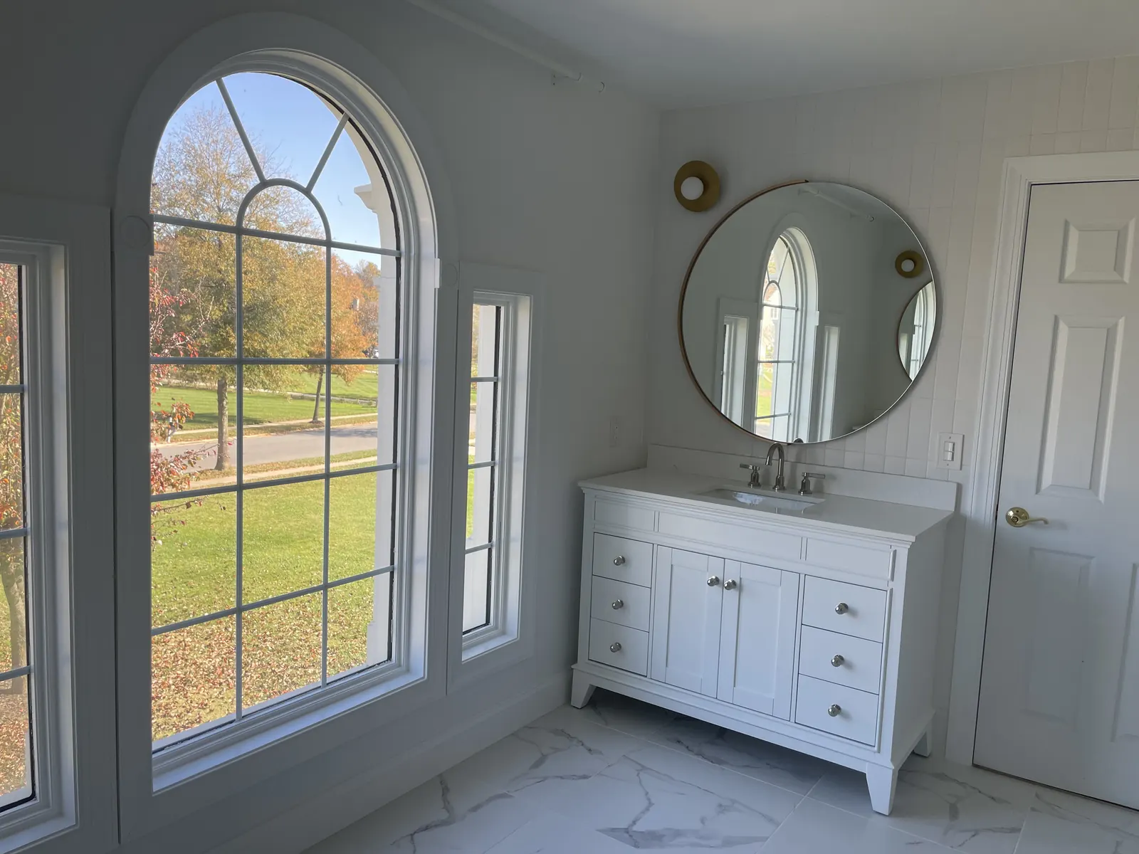 Bathroom remodel with white shaker vanity and round mirror by PRG Home Improvement in Maryland