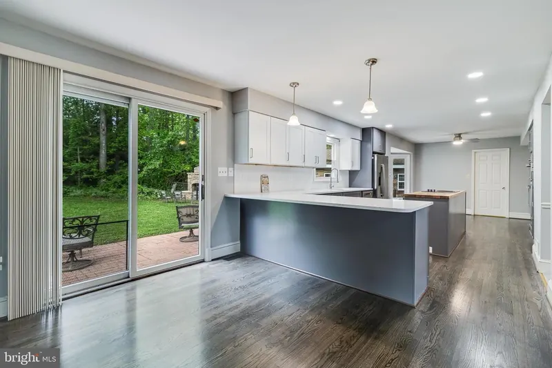 Contemporary kitchen with dark cabinetry and light granite countertops in Severn MD