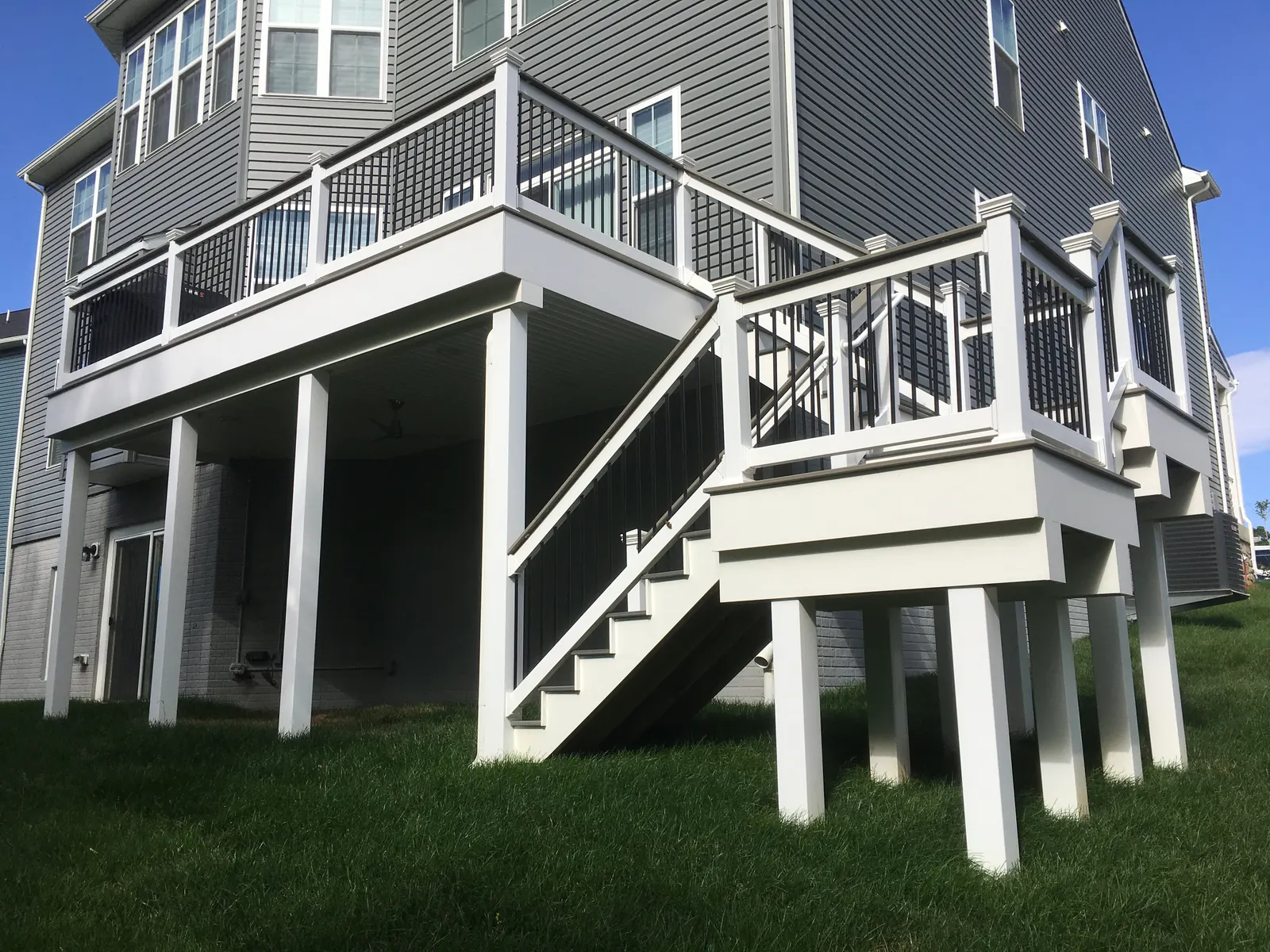 Elevated backyard deck with white railings and a staircase built by PRG Home Improvement in Maryland