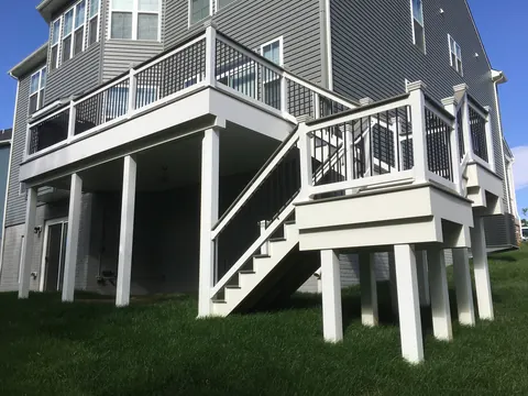 Elevated backyard deck with white railings and a staircase built by PRG Home Improvement in Maryland