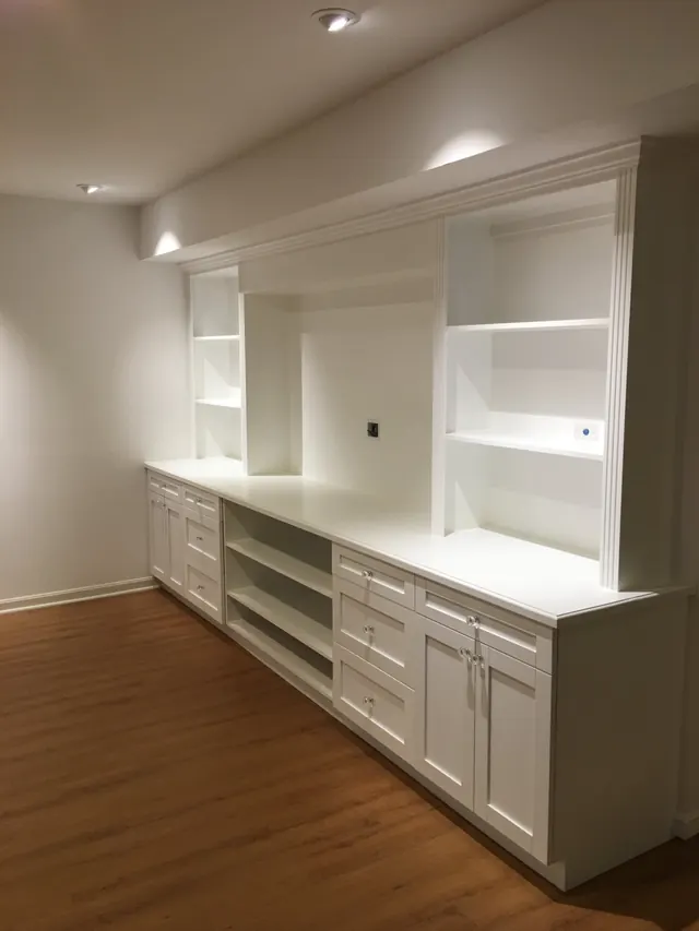 Finished custom built-in entertainment center with white shaker cabinets and recessed lighting in Ellicott City MD basement