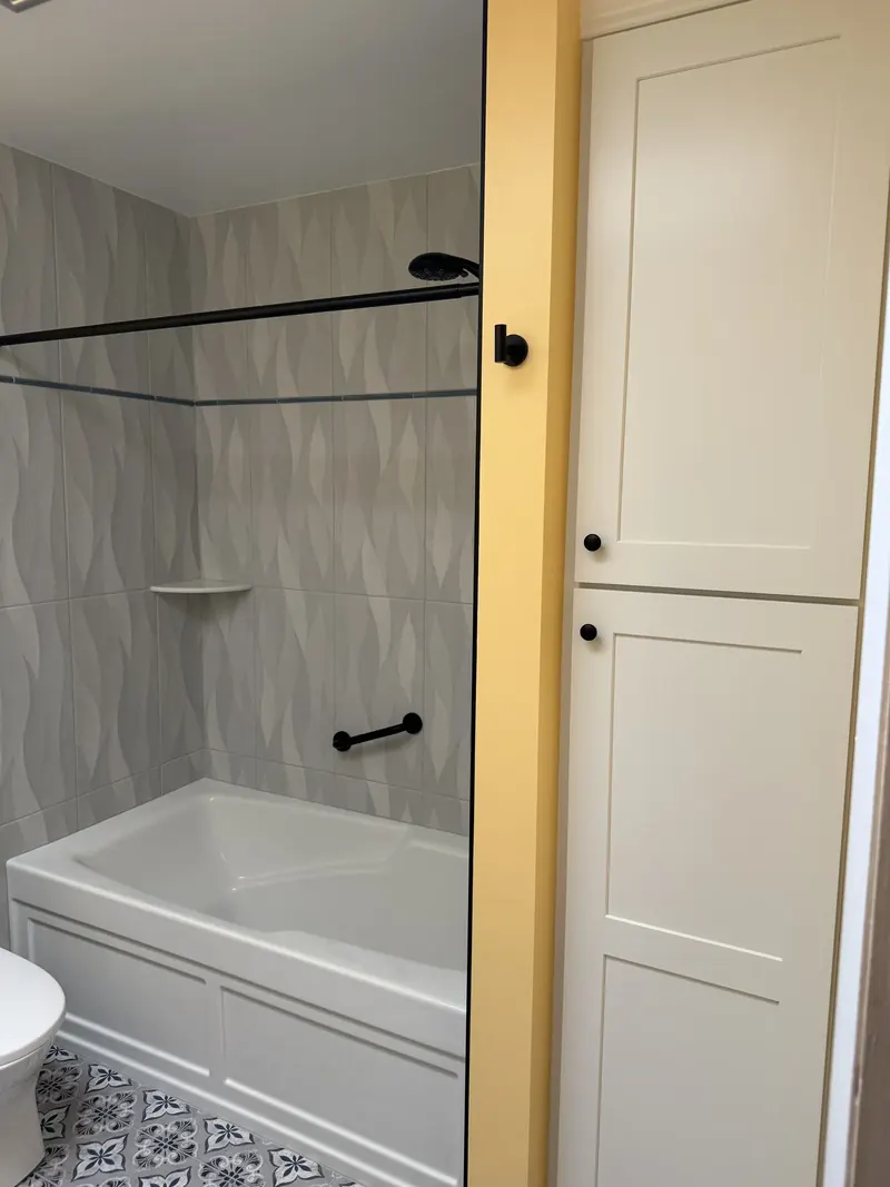 Renovated guest bathroom with patterned tile and rustic vanity in Glen Burnie MD